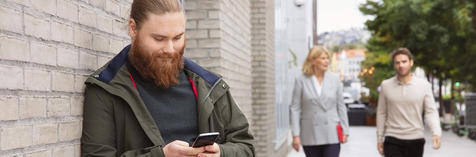 To kommer gående og en ser på mobilen