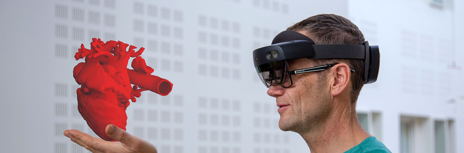 Lege Henrik Brun holder hologramhjerte i hånda